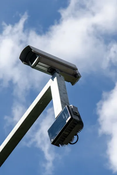 Beeld vanuit een laag perspectief van een beveiligingscamera tegen een bewolkte lucht